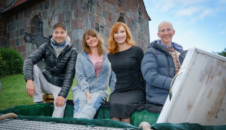 Am Set von REISEN MIT MUDDI vor der St. Matthäus Kirche in Padingbüttel im Landkreis Cuxhaven (v.l.): Ingo Rasper (Regie), Alwara Höfels (Rolle Agnetha Lakshmi Pfeiffer), Andrea Sawatzki (Rolle Naina Zareen Pfeiffer) und Valentin Holch (Autor und Produzent win win Film-, Fernseh- und Mediaproduktion GmbH) © NDR/Boris Laewen