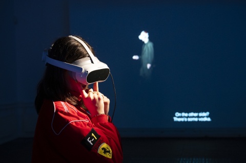 Frau mit VR-Brille im Ferrari-F1-Overall