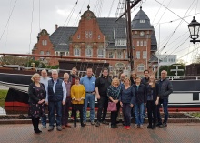 "Tatort: Drehort" - Gruppenfoto mit den Teilnehmerinnen und Teilnehmern des nordmedia-Kommunennetzwerktreffens vor dem Museumsschiff  "Friederike von Papenburg" und dem Rathaus in Papenburg