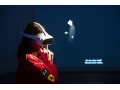 Frau mit VR-Brille im Ferrari-F1-Overall